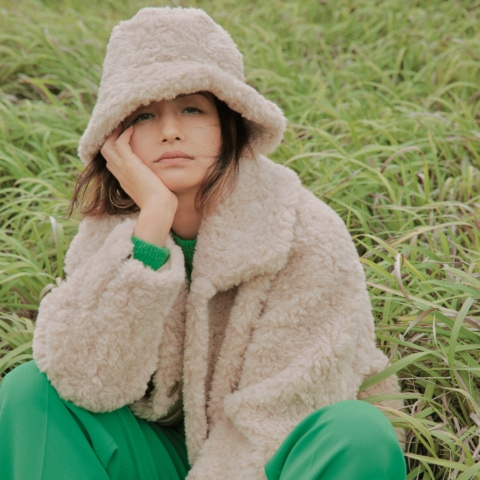 短丈トレンドの魅力を堪能できるボリューム系コートを着たモデル佐田真由美