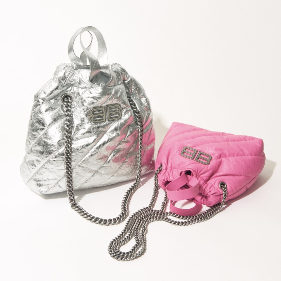 シルバーのバッグ〈クラッシュ〉［H30×W27×D10㎝］¥346,500、ピンクのバッグ〈クラッシュ〉［H20×W20×D8㎝］¥287,100（共にバレンシアガ／バレンシアガ クライアントサービス）