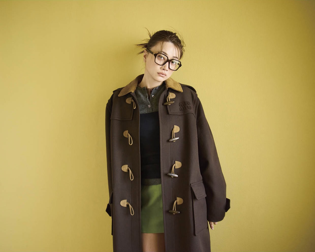 眼鏡¥55,990(ミュウミュウ/ルックスオティカジャパン カスタマーサービス)、コート¥1,155,000、ビスチェ¥138,600、グレーのニット¥247,500、ブラウンのニット¥313,500、スカート¥242,000※全て予定価格(全てミュウミュウ/ミュウミュウ クライアントサービス)