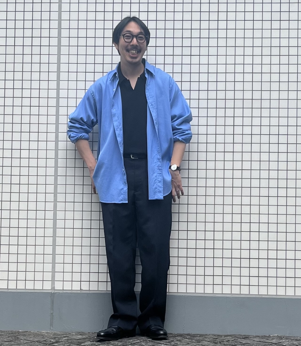 アプレッセのシャツ、バトナーのスキッパーポロ、アヴィレックス 7522のスラックス、OG by オリバーゴールドスミスのメガネ、ブレディのベルト、IWCの腕時計、ジョン ロブのローファーは工藤さんの私物