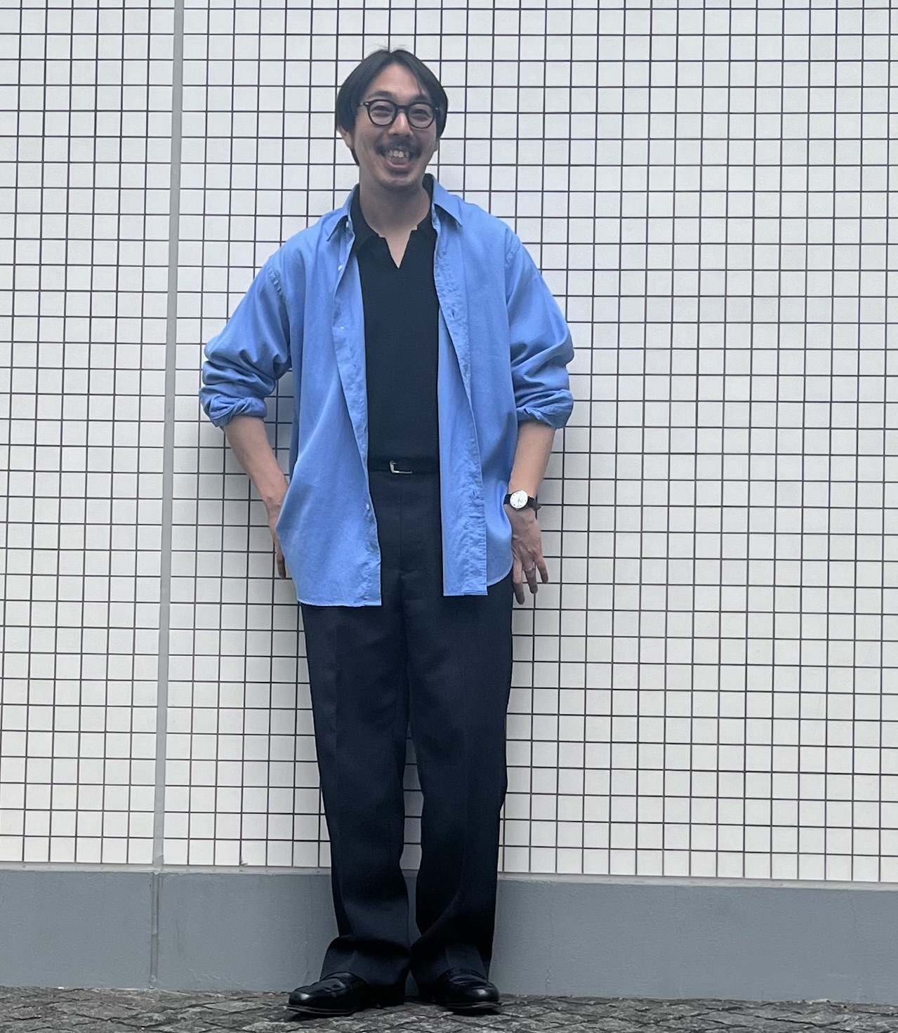 アプレッセのシャツ、バトナーのスキッパーポロ、アヴィレックス 7522のスラックス、OG by オリバーゴールドスミスのメガネ、ブレディのベルト、IWCの腕時計、ジョン ロブのローファーは工藤さんの私物