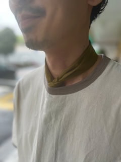 首に巻いたスカーフはコンパクトにセットするのがお決まり。こちらもアースカラーをチョイスして統一感を持たせています