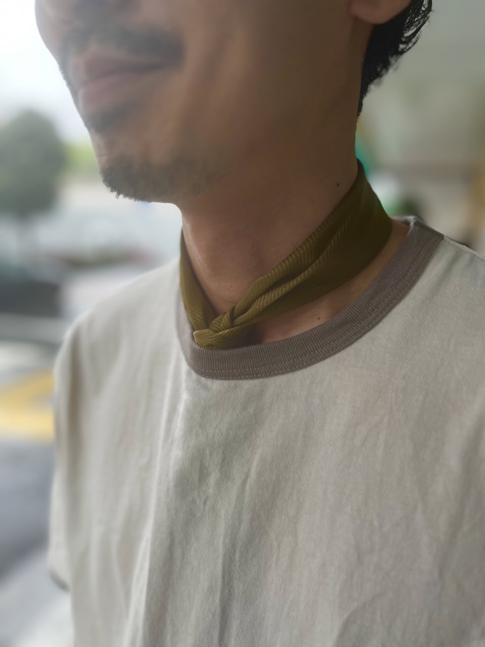 首に巻いたスカーフはコンパクトにセットするのがお決まり。こちらもアースカラーをチョイスして統一感を持たせています