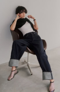 Tシャツ¥7,480（ジチピ／フォーチュンチー ジャパン）、デニムパンツ¥23,100（エディション／エディション 表参道ヒルズ店）、肩に巻いたニット¥42,900（アンスクリア／アマン）、シューズ¥20,900（モリーニ／ジャック・オブ・オール・トレーズ プレスルーム）、腕時計はスタイリスト私物
