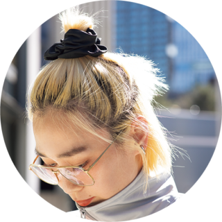 シュシュで髪をまとめて柔らかさとヌケ感をプラス。ハイトーンヘアにブラックのコントラストが◎。