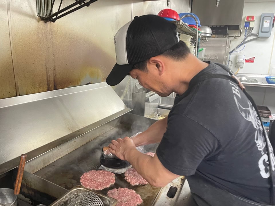【Carl OG3 Burger Shop】ムギューッとつぶし焼きしていますね。昼間は「カール・おじさん・バーガーショップ」、夜は人気のジャパニーズ焼肉「義」。いわゆる二毛作の店舗です。
