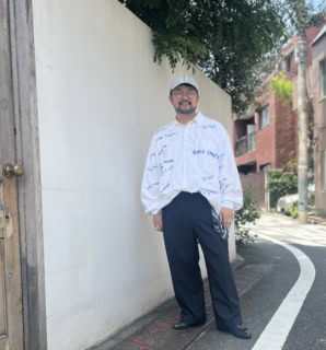 コージーのシャツ、タンジェントのスラックス、ノーブランドのキャップ、サビルローのヴィンテージのメガネ、エルメスのスカーフ、アダワット トゥアレグのシルバーアクセサリー、タニーノクリスチーのシューズは柴谷さん私物