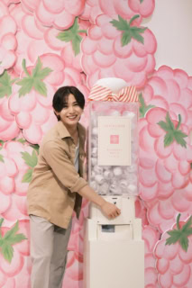 笑顔でガチャガチャを回す山田さん。