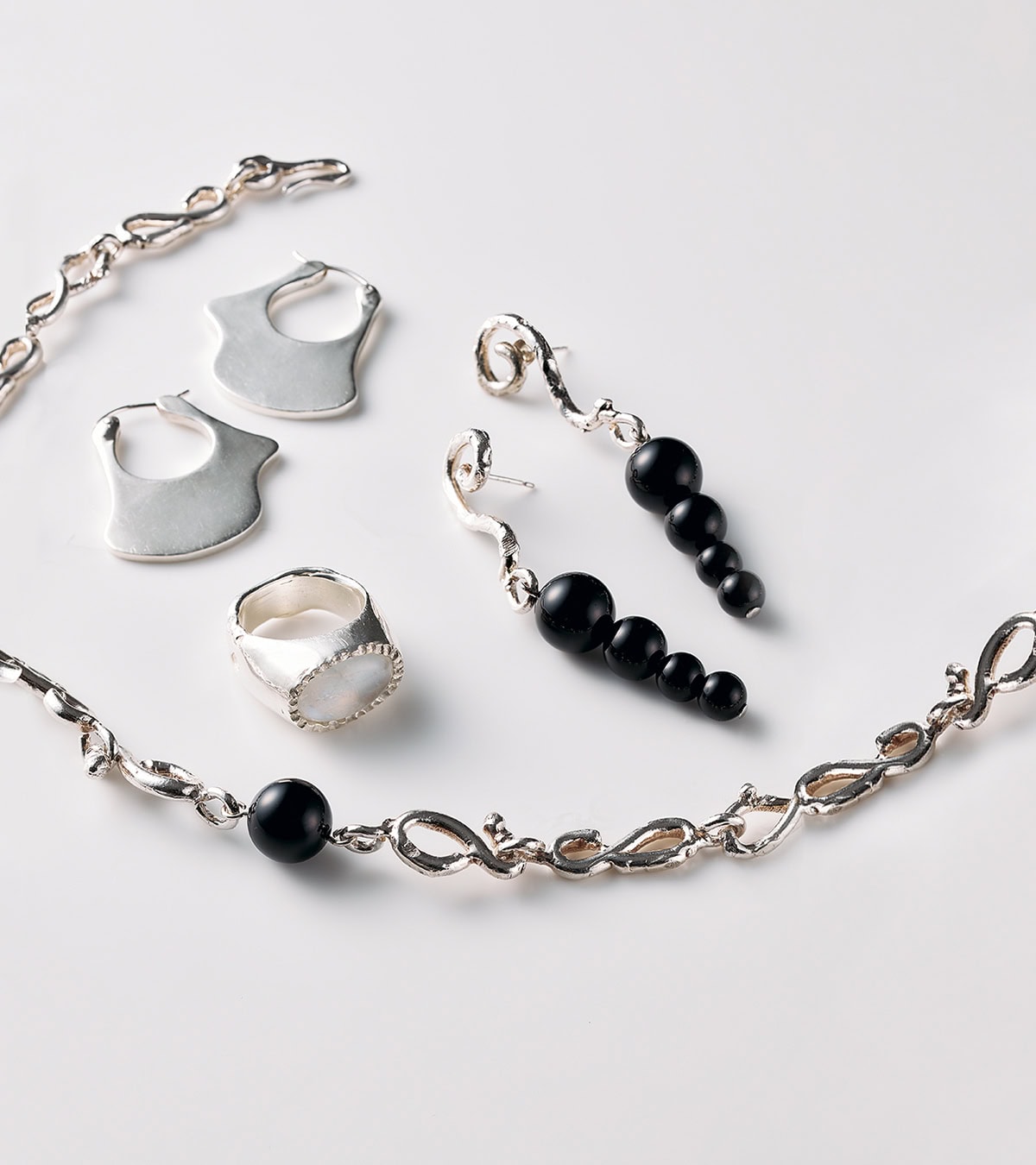 左下：ネックレス［SV×オニキス］¥48,400、左上：ピアス［SV］¥35,200、右上：ピアス［SV×オニキス］¥31,900、中央：リング［SV×ホワイトラブラドライト］¥49,500（全てゴーエン）