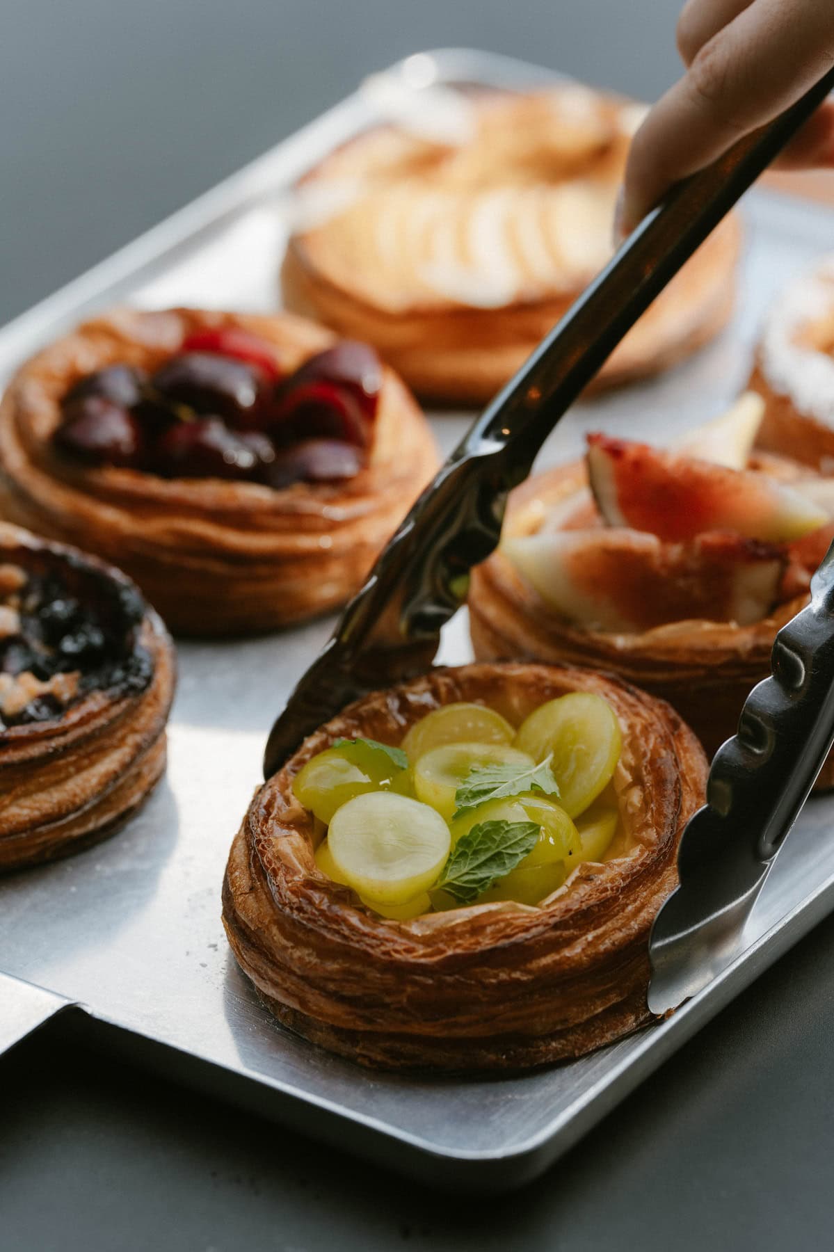 シグネチャーのクロワッサンはオーガニックシュガーでキャラメリゼすることで優しい甘さに。季節を彩るフルーツデニッシュは最高級の果物を使用し、薄い生地の食感とフルーツのみずみずしさがマッチ。