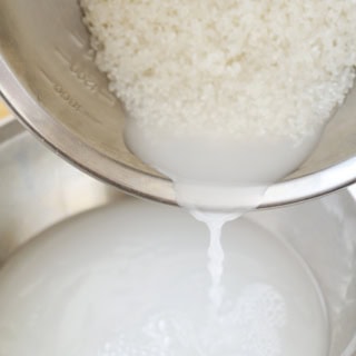1.ボウルに水を入れ、計量した米を一度に加えて、かるく手で混ぜ、すぐに水を捨てる。※金ざるは米粒の表面に傷をつけてしまうので、使用しない。