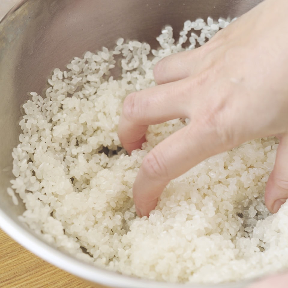 2.水のない状態で、野球ボールを握るくらいに広げた手で優しく研ぐ。水を注いで捨て、また研ぐことを3〜4回繰り返す（水が完全に透き通らなくてもOK）。