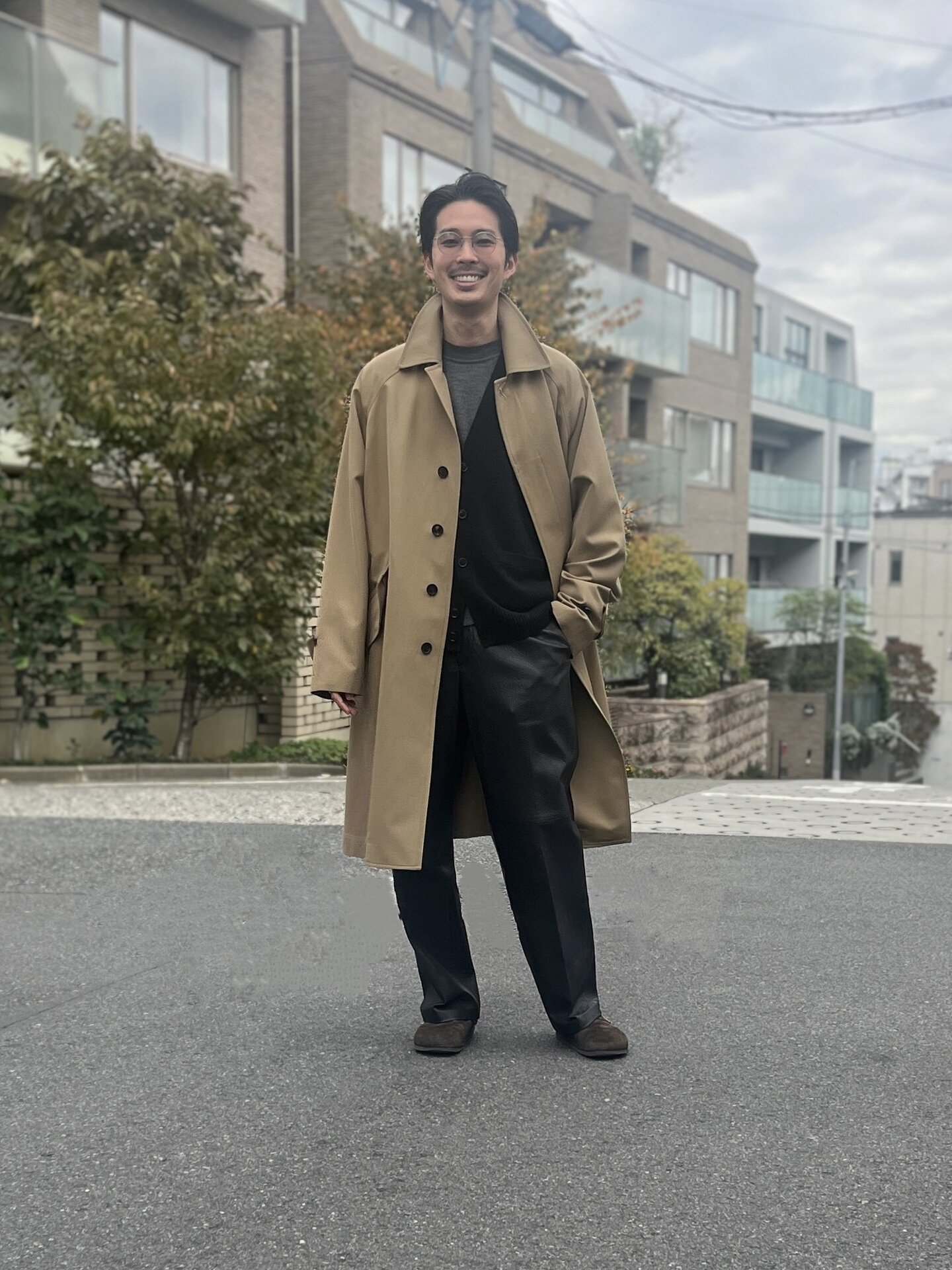 メゾン エ ヴォヤージュのコートとカーディガン、ウメダニットのクルーネックニット、エディションのレザーパンツ、オリバー ゴールドスミスのメガネ、ビルケンシュトックのシューズは井上さんの私物