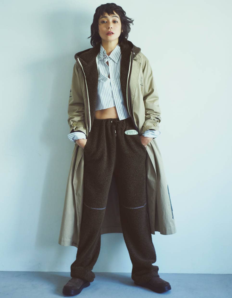 ウール混のボア素材を使用したアウトドアムード溢れるセットアップに、ストライプシャツとトレンチコートを合わせたトラッドMIXが洒落感たっぷり。ボアパーカ¥49,500、ボアパンツ¥34,100(共にザ シンゾーン/シンゾーン ルミネ新宿店)、シャツ¥66,000(オムガールズ/アダム エ ロペ)、グラフィック入りトレンチコート¥242,000(マディソンブルー)、シューズ¥53,900(フィーニー)