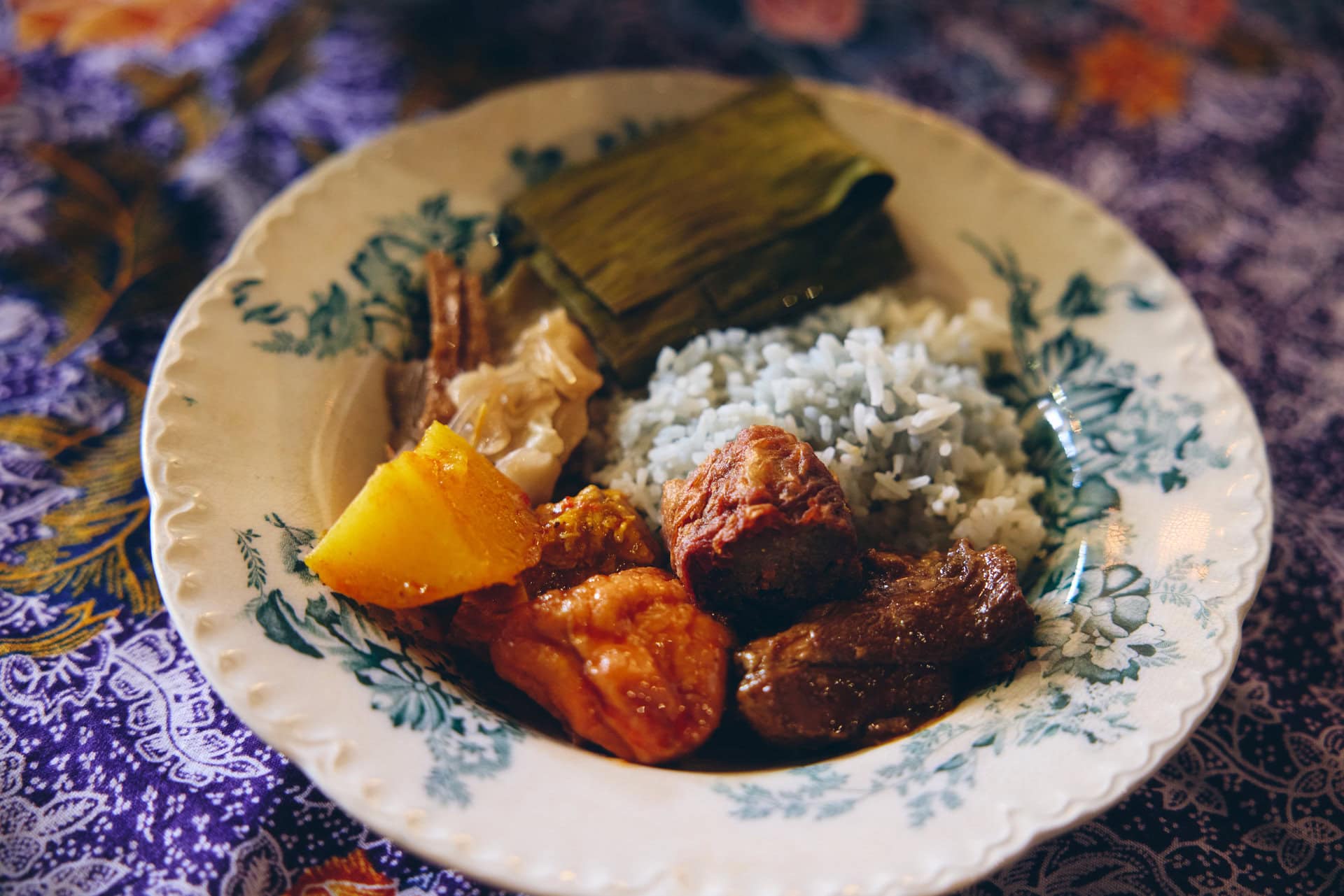 【THE INTAN】ブルーピーで色をつけたごはんに、各種料理を盛りつけてモリモリ食べるものだそう。食べ慣れないスパイスや調味料の組み合わせなどに驚きつつも、味つけはアジア料理なので日本人にも受け入れやすく、アルビンさんファミリーはたぶんお料理上手なんでしょうね、まあそれはそれは美味！ お肉などの食材がいちいち「イイもの使ってるな」って感じなんです。