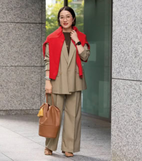 ベージュのセットアップをメインにワントーンでまとめたキレイめなスタイルは、旬のカラー、真っ赤なニットとゴールドフレームの眼鏡で華やかな雰囲気に。