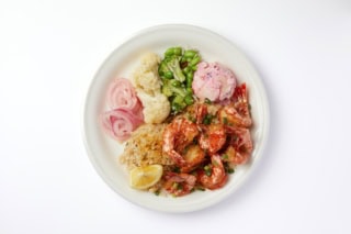 プリプリの殻つき海老をスパイスとガーリックたっぷりで炒めたノースショア・カフクの名物料理。ピンク色のカタマリはマカロニサラダです。ガーリックシュリンププレート¥1,700