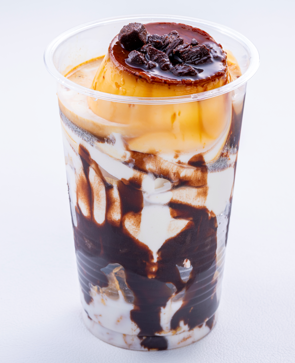 別府・明礬名物、岡本屋の地獄蒸し®️プリン。丁寧に蒸し上げた濃厚なカスタードとほろ苦いカラメルが絶妙な味わいのプリンをソフトクリームと生クリーム、チョコレートソースでパフェ仕立てに。地獄プリンパフェ ¥900