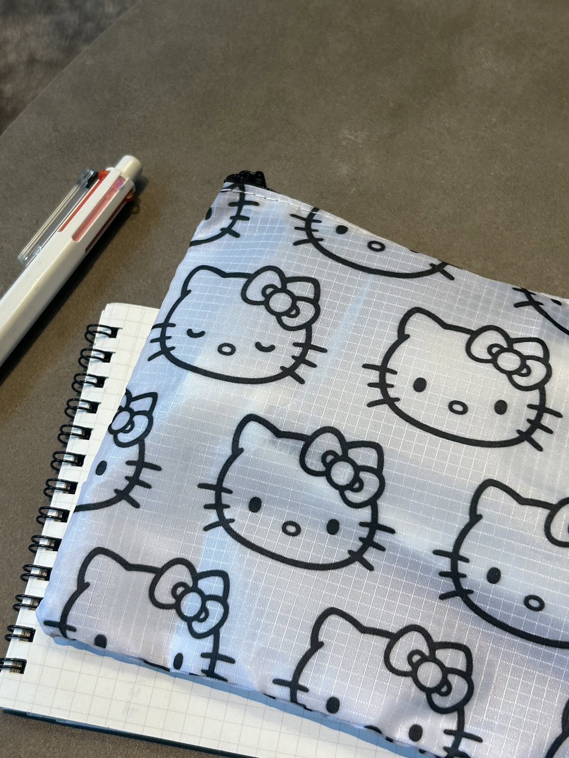 表情の異なるハローキティの総柄です。ノートやペン、ガジェットまで、細々した小物をまとめて。