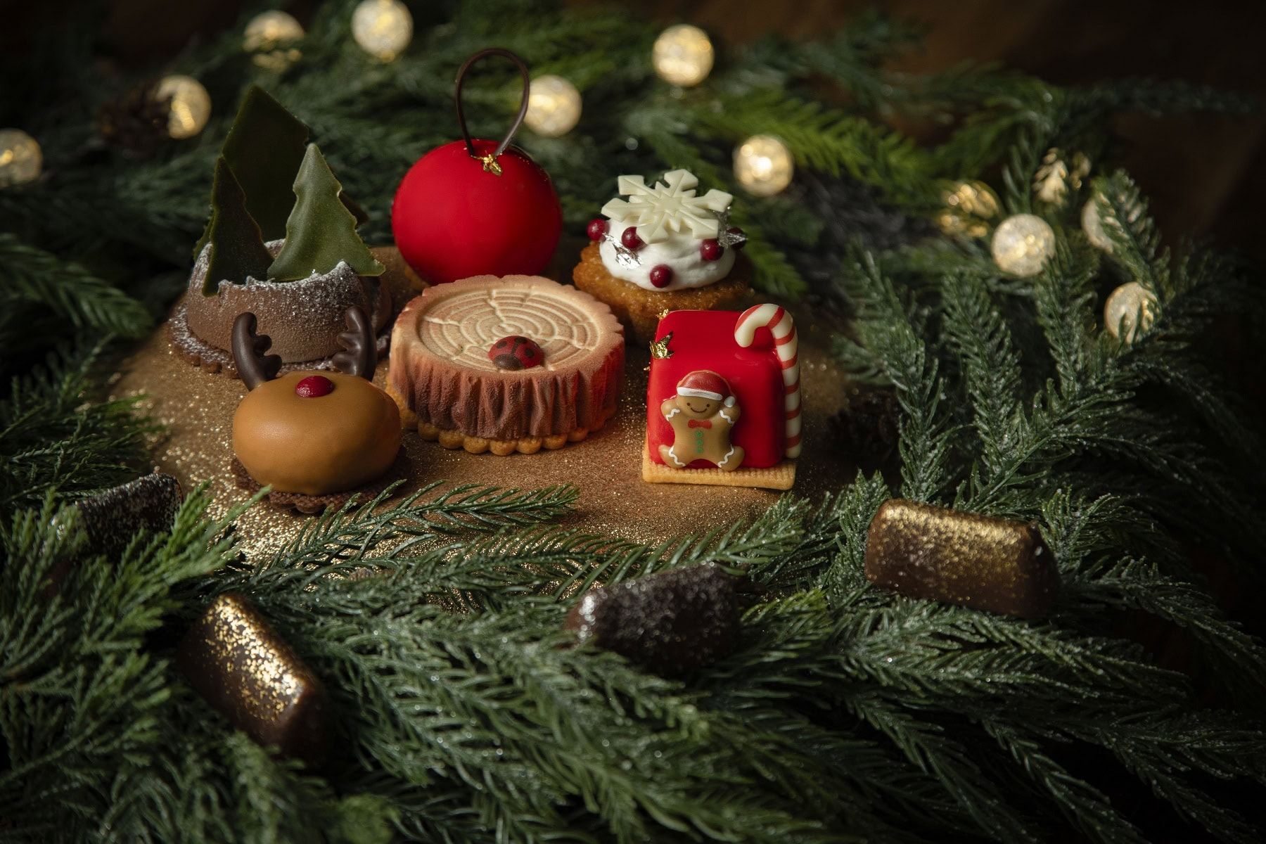 中央上から時計回りに：クリスマスボール、栗のフィナンシェ、クリスマスギフトボックス、ミニブッシュジャンドゥーヤ、テントウムシミニウッド、トナカイ、クリスマスツリー
