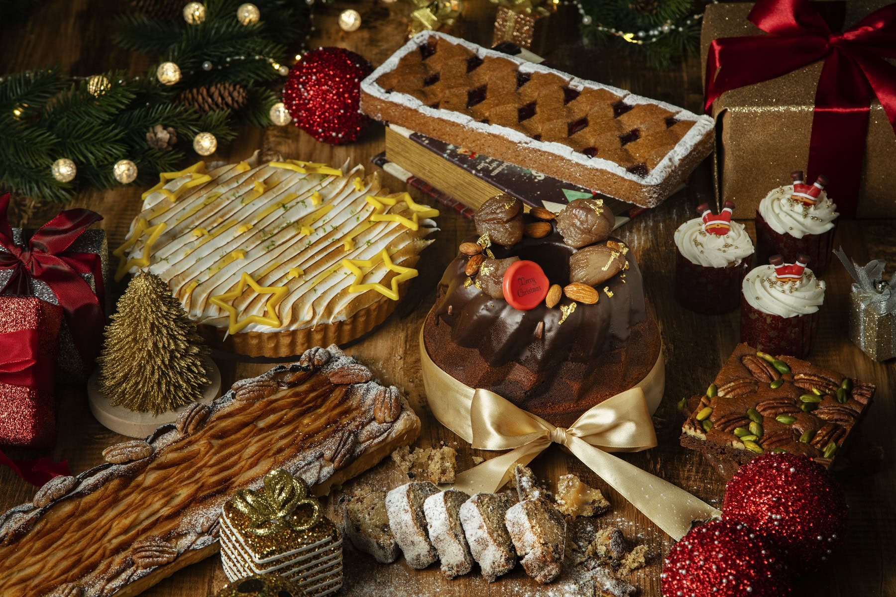 中央上から時計回りに：リンツァータルト、パン・デピスカップケーキ、ナッツブラウニー、マーブルクグロフ、シュトーレン、林檎とピーカンナッツのパイ、レモンタルト