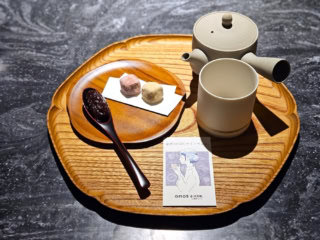 輪島漆器の四十沢木材工芸「KITO」のトレーに小皿、輪島塗「田谷漆器店」のドキッとするほどなめらかな触感のカトラリー、お茶を飲むのに最適な常滑焼「南景製陶園」の急須、さらにあえて無地の九谷焼「HANASAKA」の湯呑。「古都美」のほろっと優しい味わいのクッキーに、「茶菓工房たろう」のあえてそのままの餡を、自分で淹れた加賀棒茶とともに。