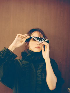 ラッフル付きブルゾン「Michel（ミッシェル）」1,728€、⾸に着けたラッフルカラー ※写真のカットでは着⽤していないシャツとのセット販売「Valerie（ヴァレリー）」1,242€、⼿に持ったガラスパールのつけ襟「Colette（コレット）」459€ ※全て参考価格（全てエコール・ド・キュリオジテ）