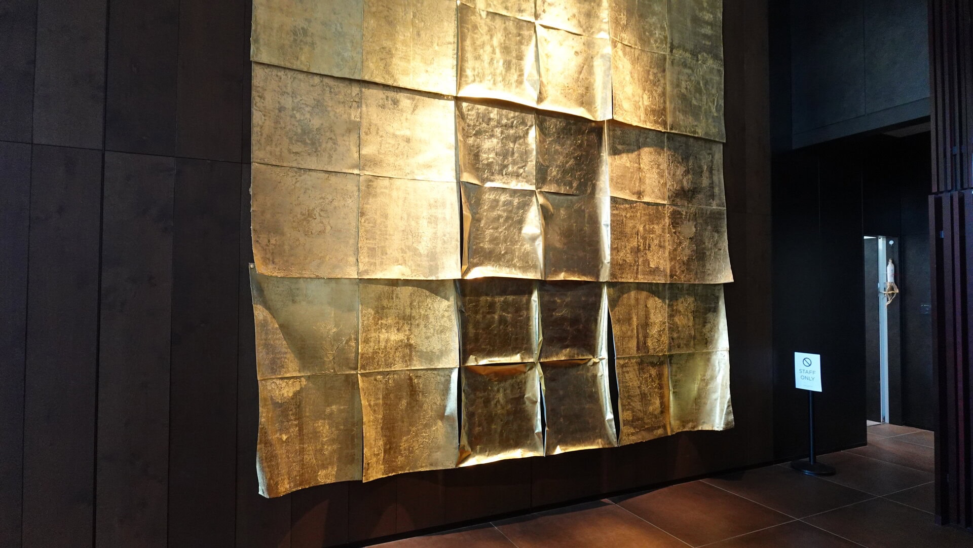 箔デザイナー高岡愛氏による大判の金箔アート。空間に自然と溶け込んでいるけれど、近づくほどにその迫力に圧巻。引きで空間全体を楽しむのも至福、間近で細部に宿るこだわりを実感するのもまた至福！