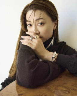 人さし指リング〈エクスリブリス〉［SV×PG］¥261,800、中指リング〈シェーヌ・ダンクル・アンシェネ〉［SV］¥130,900、ブレスレット〈トルサード〉［SV］¥613,800、スカーフ¥46,200、ニット¥359,700、パンツ¥1,650,000（全てエルメス／エルメスジャポン）