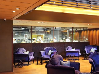 ガラス張りの半オープンになった活気あふれるキッチンを通って食事処へ。