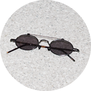 「顔の印象が引き締まるダブルブリッジ。細身のオーバルレンズ、好きなんです」。プロジェクト プロダクトのサングラス／本人私物