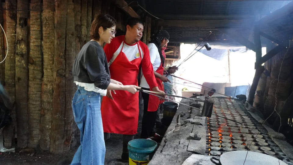 灰が舞う作業場で塩作りにトライ。右下に見える桶に入った海水を右手で小さな壺に移し、左手で泡を潰す作業を何度も何度も繰り返していきます。赤いエプロンのお兄さんは簡単そうに淡々とこなしていましたが、とても難しい繊細な作業に、1つの塩壺ができるまでの苦労を垣間見ることができました。