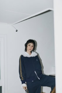 チェックポップコーンキンチャクS［H26×W21㎝］¥3,960、トラックジャケット¥7,920、ブラウス¥6,930、ラインパンツ¥6,930（全てシテン／ユナイテッドアローズ カスタマーサービスデスク）、ピアスはスタイリスト私物