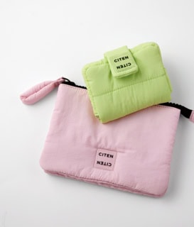 上から：ミニバッグにも入るサイズ感。ミラーツキミニポーチ［H9×W11.5×3.5㎝］¥2,530、真ん中に仕切りがあり、使い勝手抜群。2ポケットポーチ［H14×W19×D2㎝］¥2,200