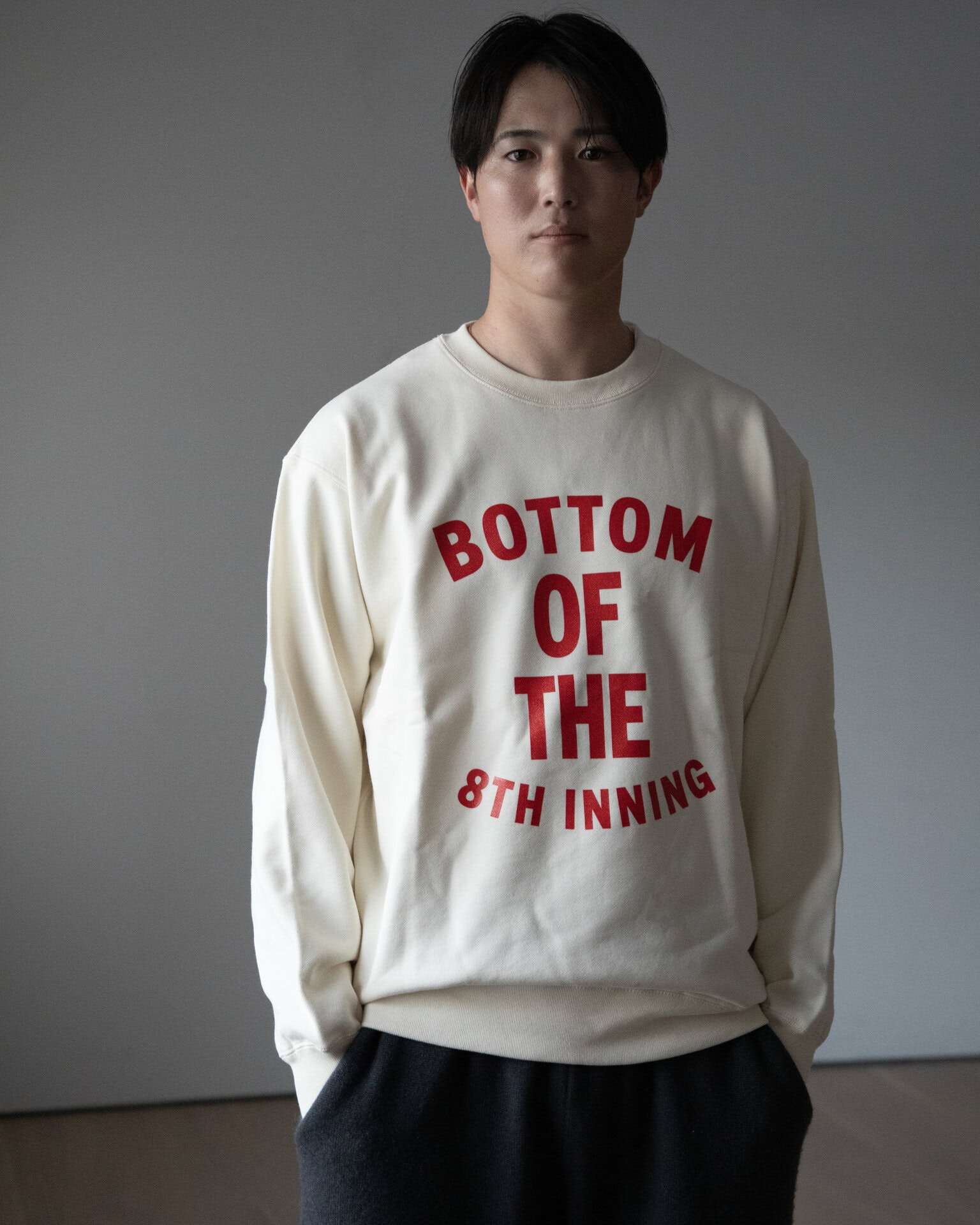 サラリと着るだけで様になるデザイン。森下選手のように長身の人でも着られるサイズ展開（S～XXL）も嬉しい。8回の裏スエット￥15,400（Fmill Studio）