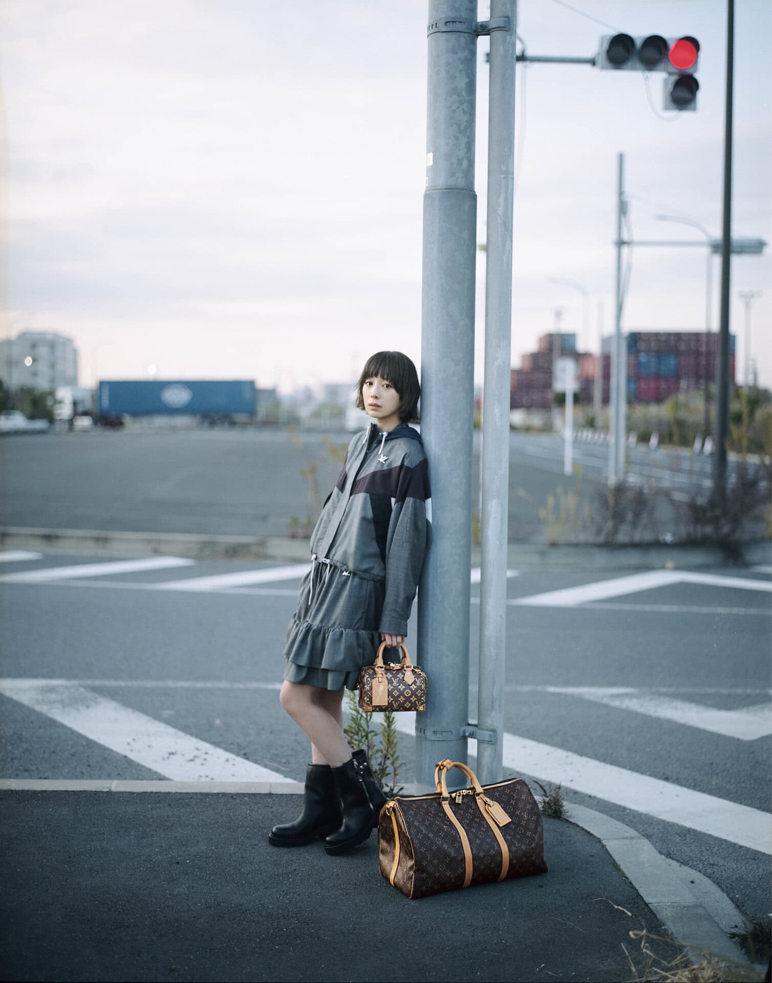 バッグ〈スピーディ・トランク〉［H13.5×W20.5×D11㎝］¥529,100、下に置いたバッグ〈キーポル・バンドリエール 50〉［H29×W50×D23㎝］¥423,500※共に取り外し可能なストラップ付き、ブルゾン¥720,500、スカート¥311,300、ブーツ［ヒール4㎝］¥313,500（全てルイ・ヴィトン／ルイ・ヴィトン クライアントサービス）