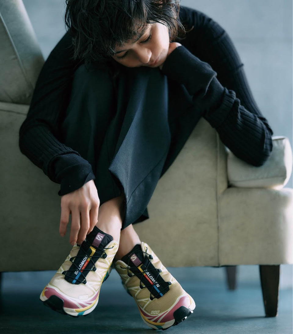 キレイめにもモードにもマッチするモダンなデザインが人気。オールブラックのコーデにカラフルな足元がいいアクセントに。スニーカー〈XT-6〉¥28,600（サロモン／アメアスポーツジャパン）、ニット¥27,500、パンツ¥35,200（共にインパーフ）