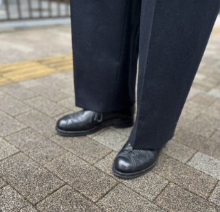 レースアップのデザインが個性的なシューズが、シンプルなジャケットスタイルのさりげないアクセントに