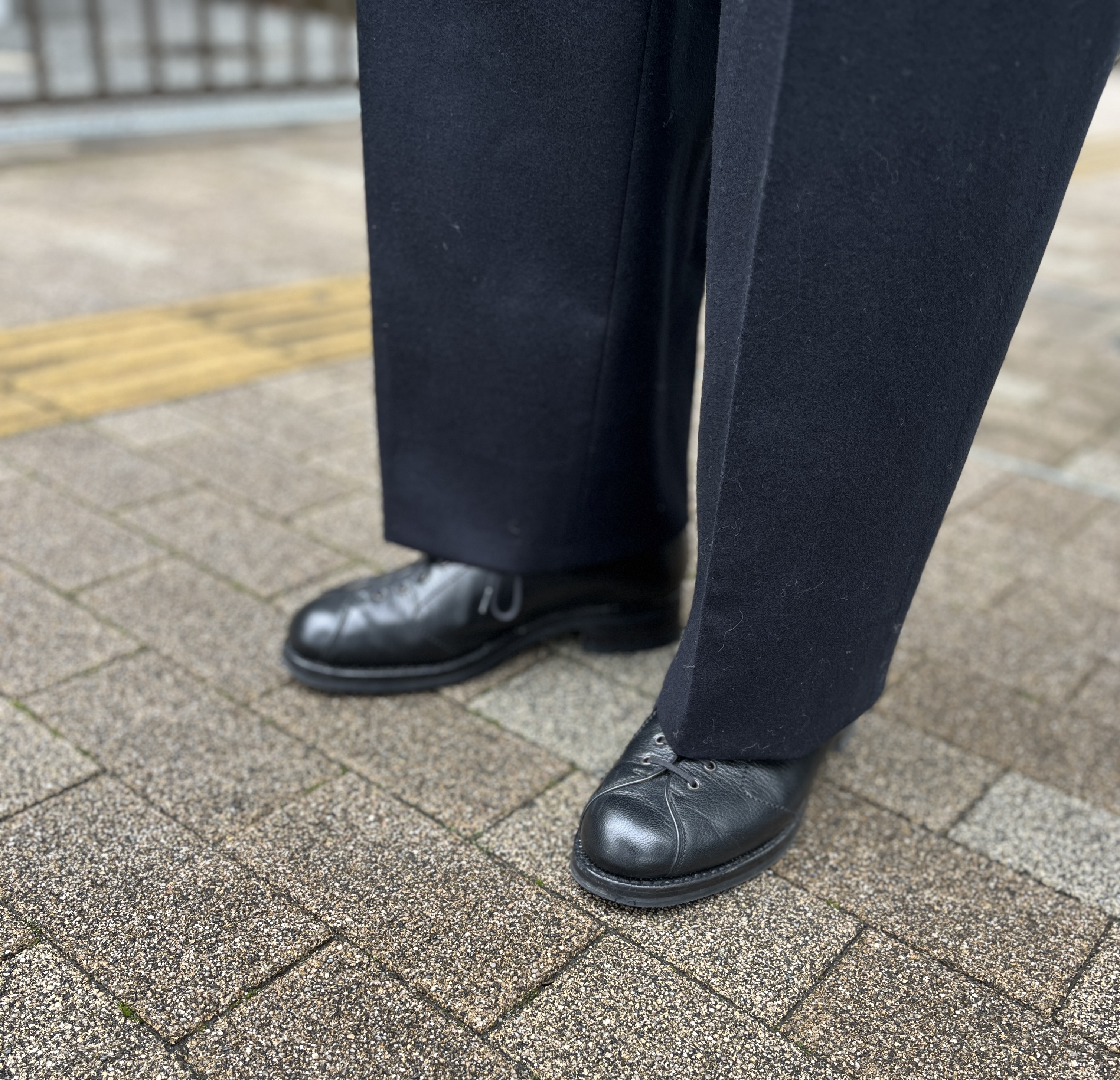 レースアップのデザインが個性的なシューズが、シンプルなジャケットスタイルのさりげないアクセントに