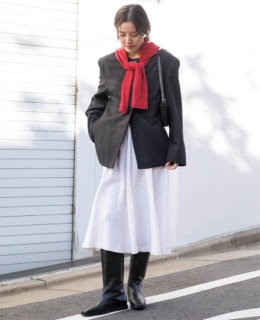 アモーメントのジャケット、肩に掛けたオニットのカーディガン、ヴィンテージのスカートとバッグ、スタジオ ドーのブーツは全て本人私物