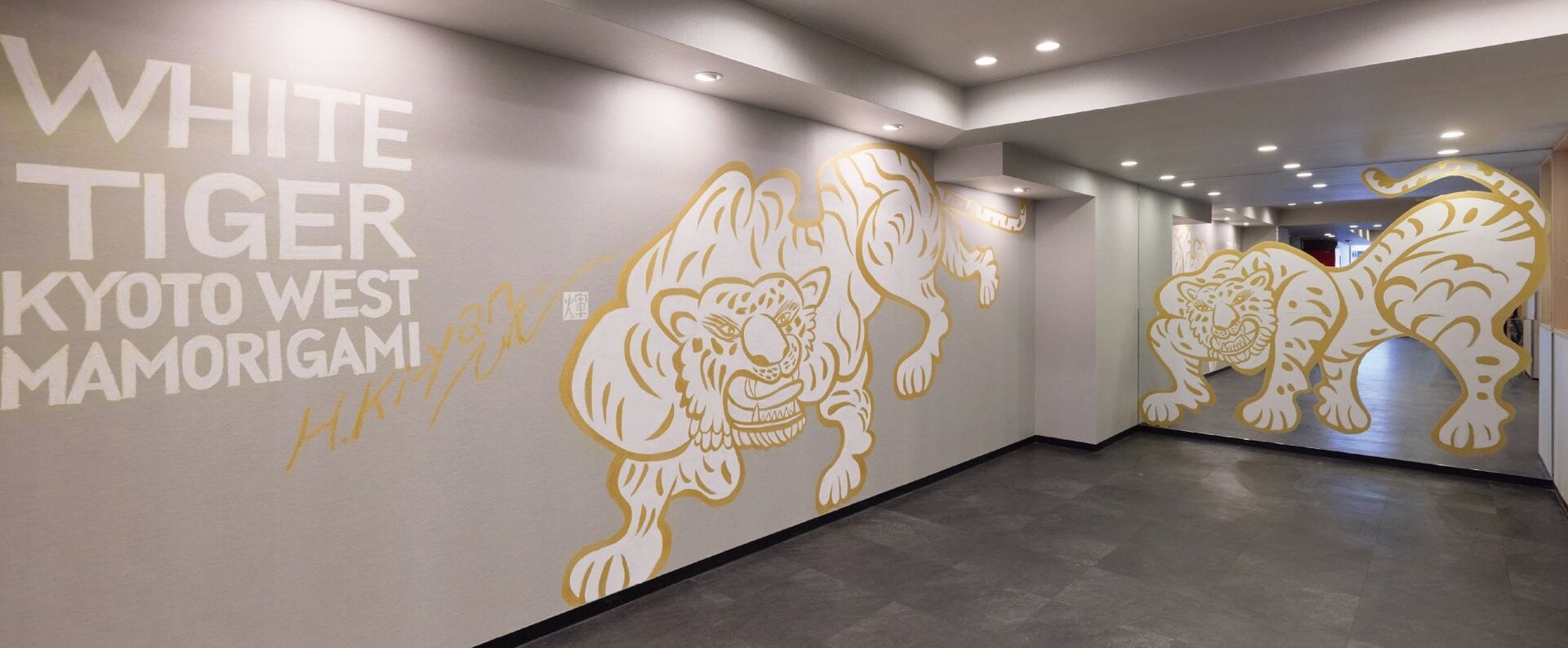 完成したばかりの「白虎」の壁画。京都の西を守護する神獣「白虎（びゃっこ）」は。京都は古来より、東西南北を四神（青龍・白虎・朱雀・玄武）が守護する「四神相応の都」として知られています。西方を司る白虎は、二条や嵐山をはじめとする京都西部を見守る象徴で、「アゴーラプレイス 京都二条」とも立地的に深い縁を持つ存在。