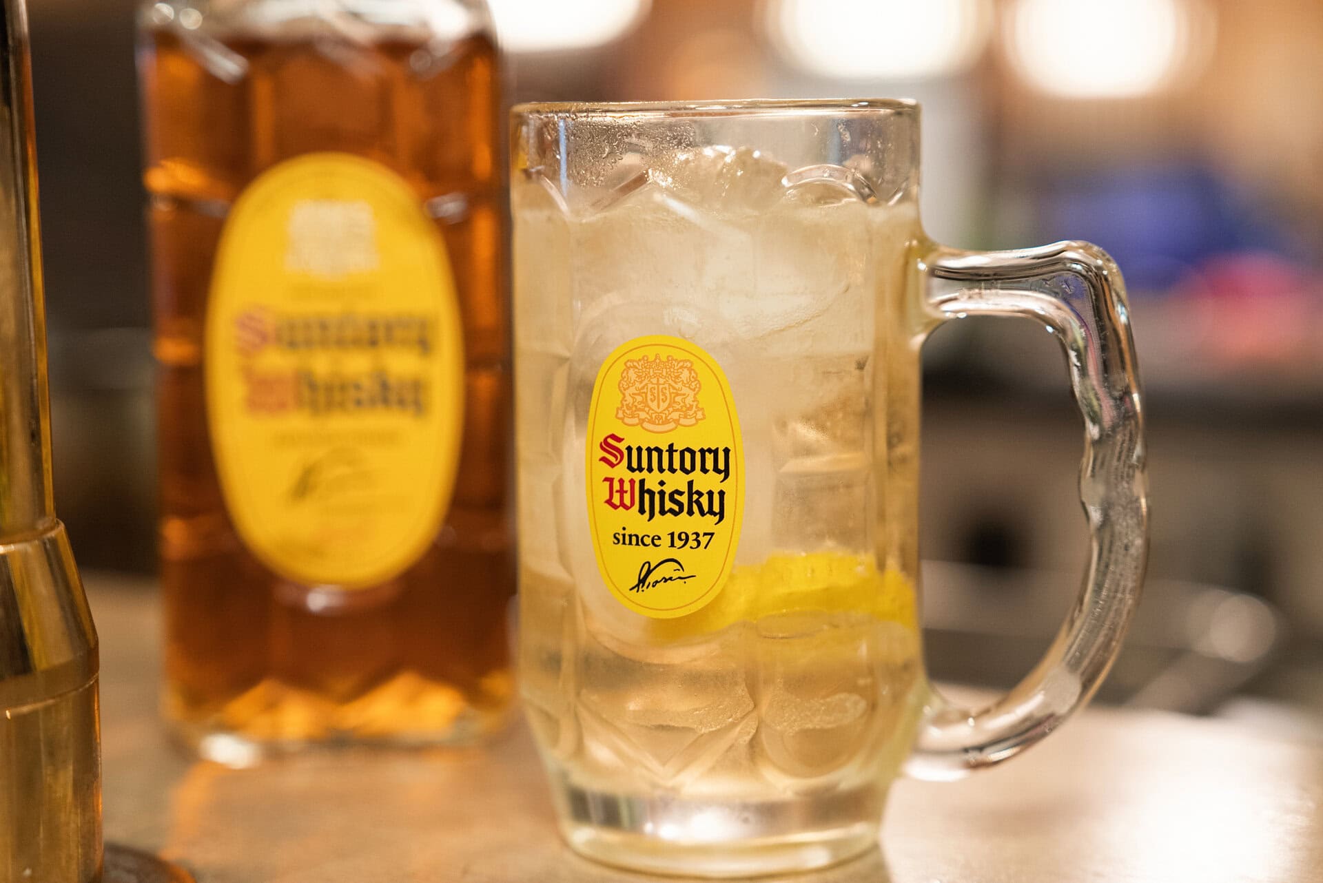 店内に足を踏み入れると、目に飛び込んでくるのは専用のハイボールタワー。「メニューにある“角ハイボール”を頼むと、ここでは必然的に“別格角ハイボール”が出てくるということなんですね。普通のハイボールとは何が違うんですか？」興味津々のダーリオの前に差し出されたのは、凛とした佇まいのグラス。早速一口運んだダーリオの瞳がパッと輝きます。