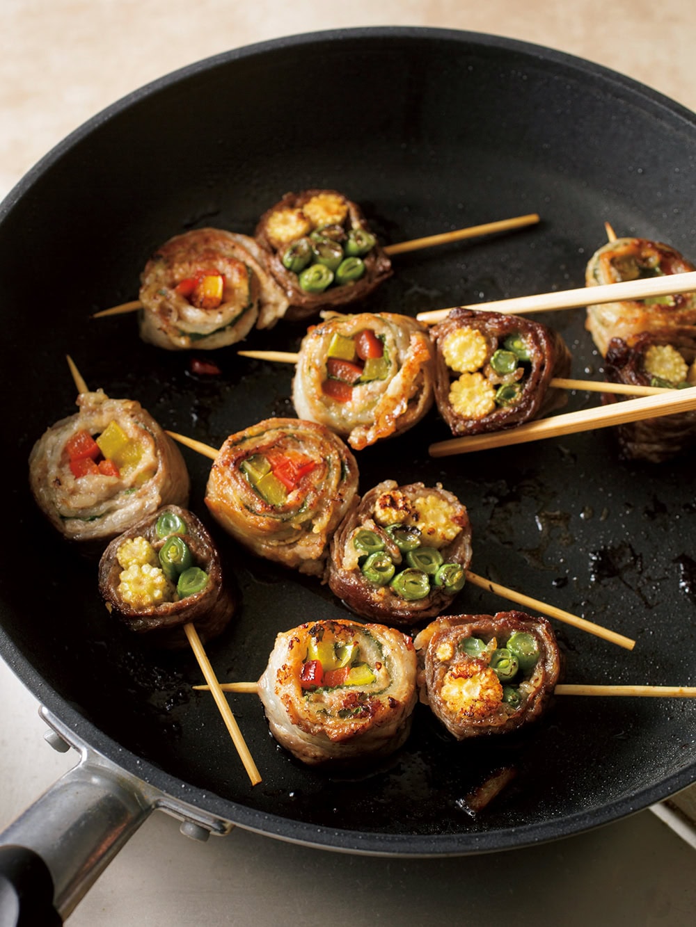 4 フライパンにサラダ油大さじ1/2を中火で熱し、3の半量を側面が下になるようにして入れる。こんがりと焼き色がついたら上下を返し、転がしながら全体に焼き色がつくまで3~4分焼く。酒大さじ2をふってふたをし、弱火にして3分ほど蒸し焼きにする。残りも同様に焼く。