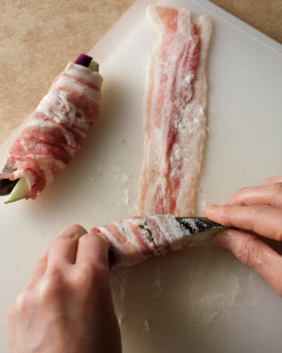 1.豚肉を2枚1組にしてまな板に広げ、塩、こしょうをふって小麦粉適量を茶こしで薄くふる。なす1/8量を手前側にのせ、端から少しずらしながら斜めにくるくるとしっかり巻く。手で全体をぎゅっとにぎり、小麦粉適量を薄くまぶす。残りも同様に作る。