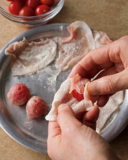 1.豚肉は半分に切って広げ、小麦粉適量を茶こしで薄くふる。豚肉1/2枚でミニトマト1個を包み、手でぎゅっとにぎる。塩、こしょうをふり、小麦粉適量を茶こしで薄くふる。