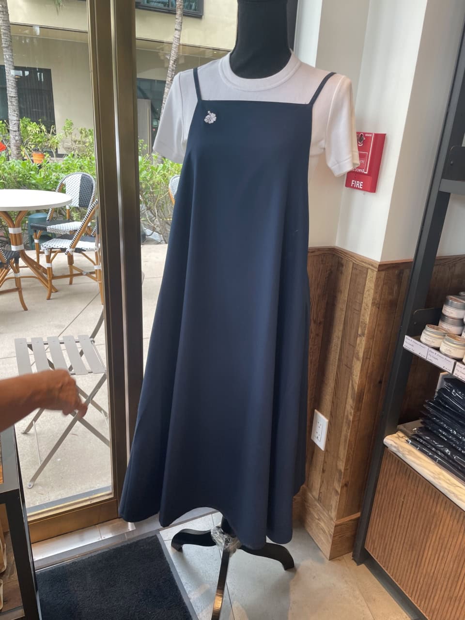 【カカアコ・コウラ店】ストンと落ち感のある素材のエプロンは前から見たらAラインドレスのようなルックス。バッグがクロスになって、レディな雰囲気。エプロン65ドル（日本円で約10,400円）