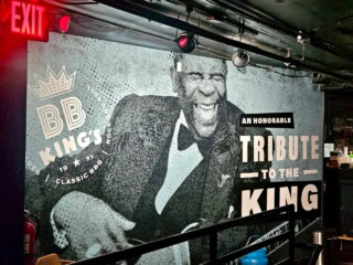 【B.B KING’S BLUES CLUB】壁にはB.Bキング師匠がドーン! ステージに向かって笑いかけているように飾られています。