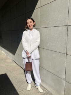 ニット、シャツ、スエットパンツ、レザーシューズと異なる素材のホワイトを上手に掛け合わせているので、のっぺり感は皆無。ポイントに1点投入したブラウンのバッグが洒落感を一層加速させる。