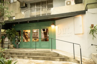 お店に一歩足を踏み入れると、そこはまるでお洒落な紳士服の仕立て屋さんのよう。「え、ここがパイナップルケーキ屋さん？」と、ダーリオも思わずキョロキョロ。実は、いくつもあるドアの中から“正解”を見つけないと、ショップへは辿り着けないというユニークな仕掛けになっているんです