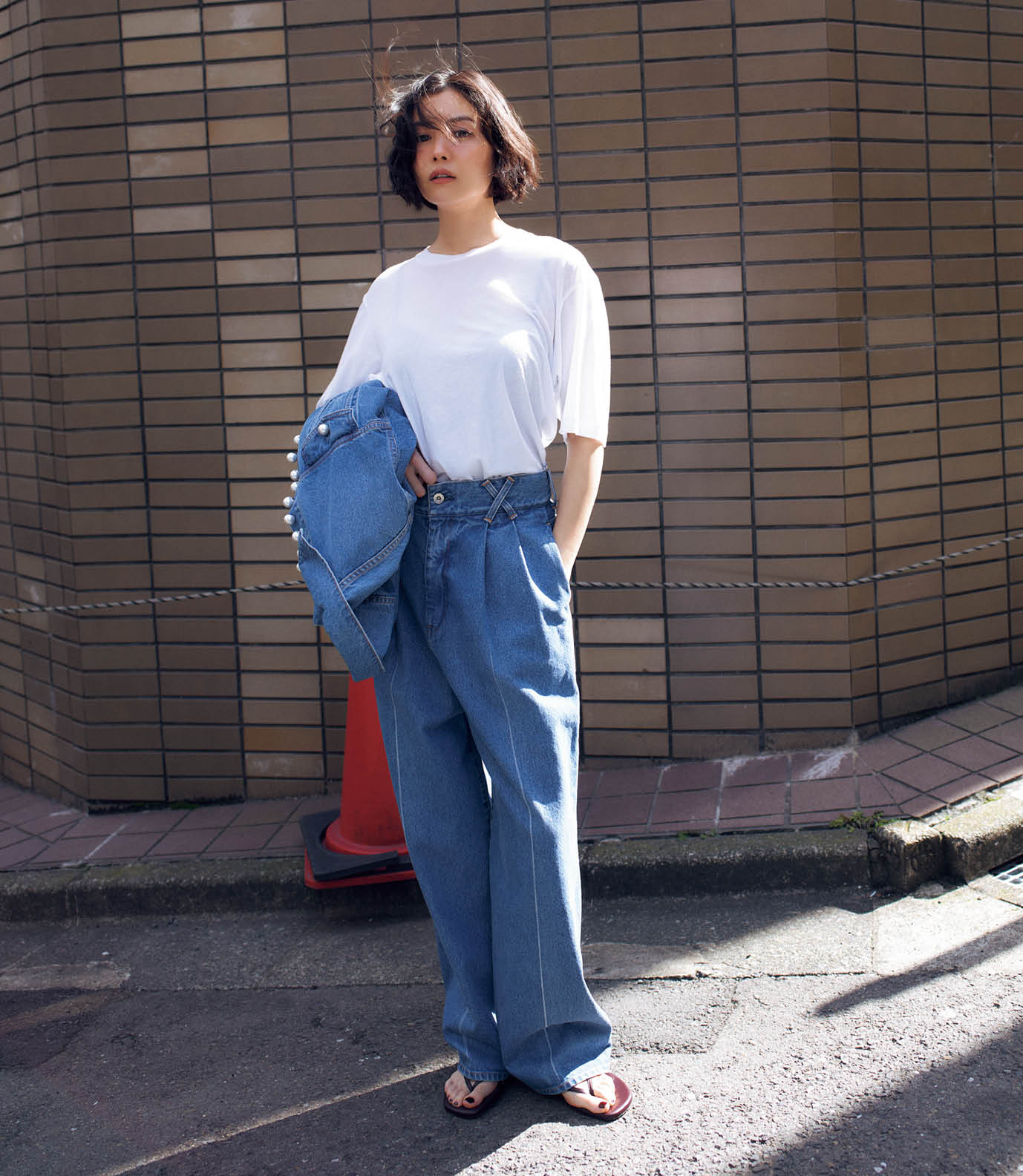 Tシャツ¥15,400、手に持ったデニムジャケット¥99,000、デニムパンツ¥49,500(全てチノ/モールド)、サンダル¥10,780(ル タロン/ル タロン 有楽町マルイ店)、インナーはスタイリスト私物
